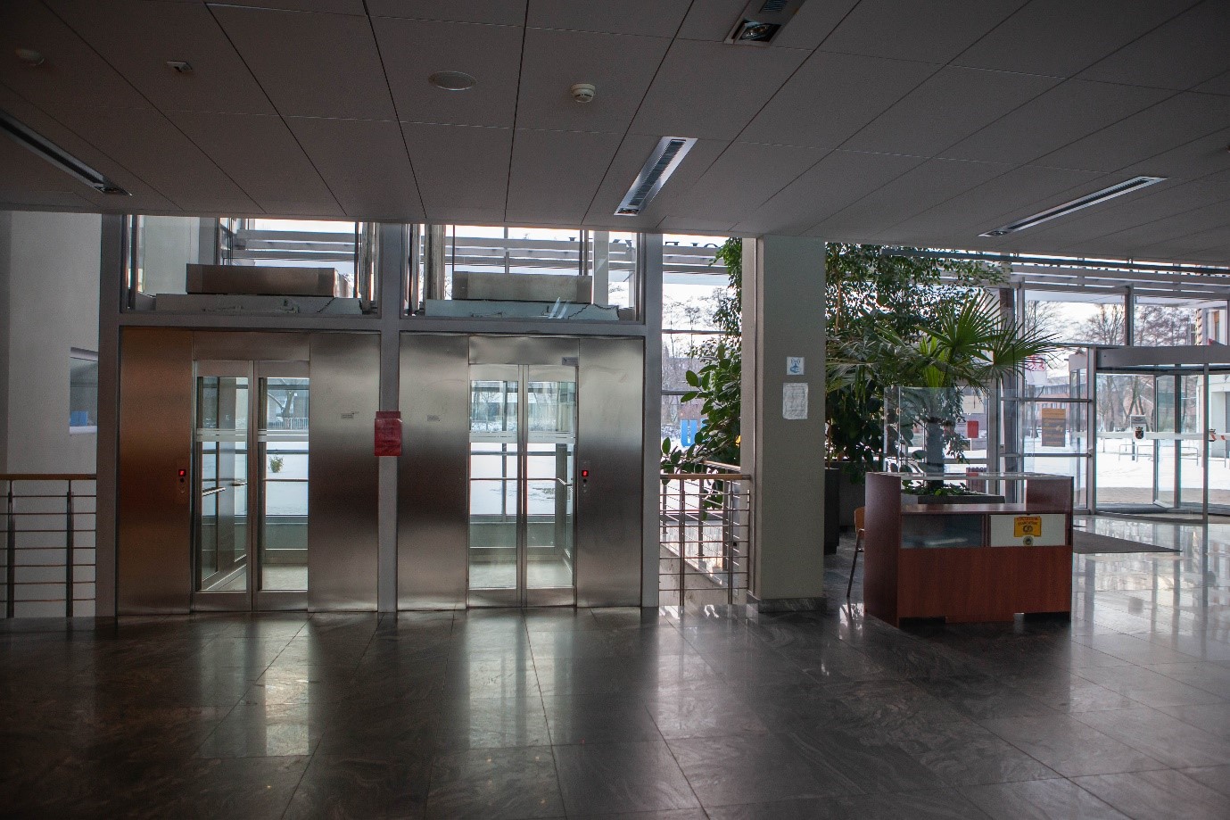 Hol budynku Wydziału Zarządzania i Komunikacji Społecznej. Z lewej windy, z prawej przeszklone wejście główne.